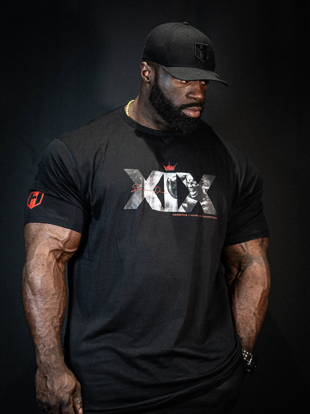 Bodybuilder Samson Dauda wearing the Mr. Olympia #19 Samson Dauda t-shirt in the gym#color_black