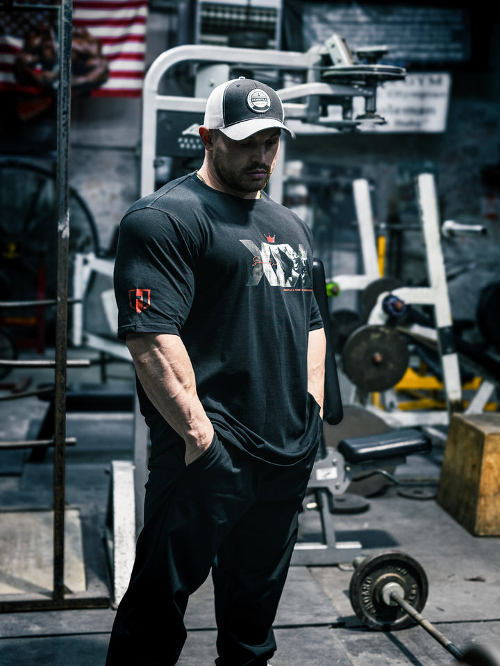 Bodybuilder Martin Fitzwater wearing the Mr. Olympia #19 Samson Dauda t-shirt in the gym#color_black